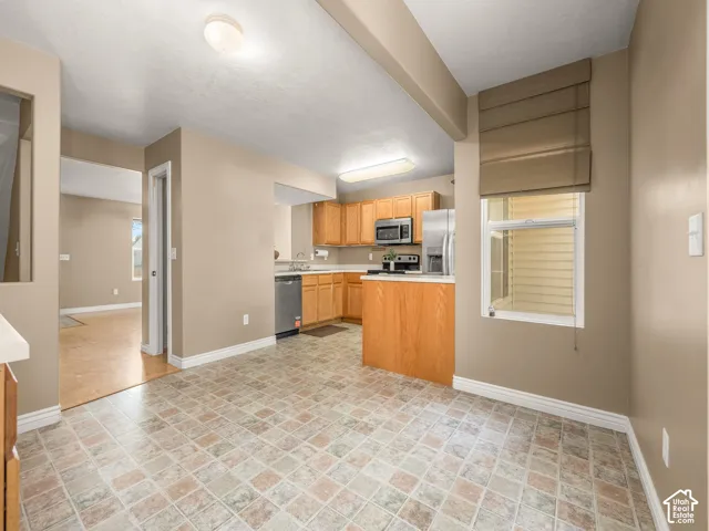 Kitchen featuring wood cabinetry, stainless steel appliances, and a breakfast bar