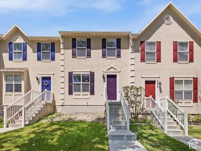 Townhome exterior featuring a stucco finish and gabled rooflines