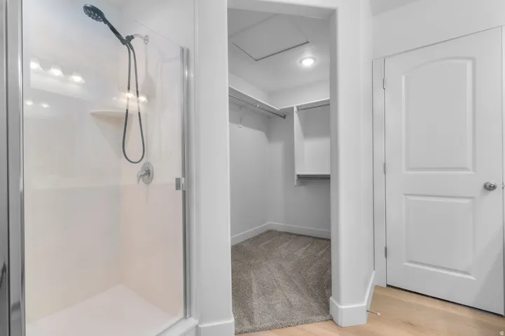 Walk-in shower with clear glass enclosure and chrome fixtures