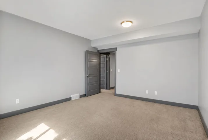 Neutral-toned carpeting paired with light grey walls and dark grey trim