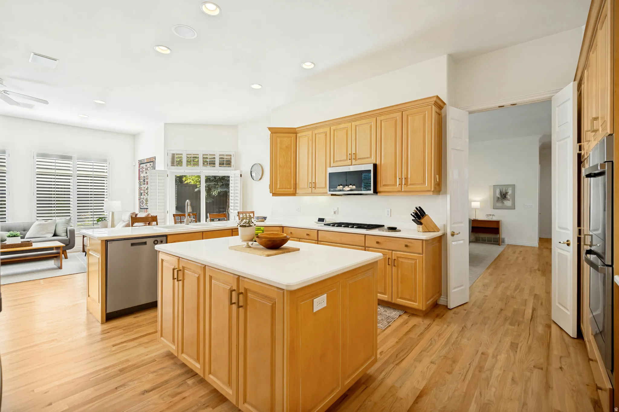 Spacious kitchen featuring maple cabinetry, light countertops, and updated stainless steel appliances