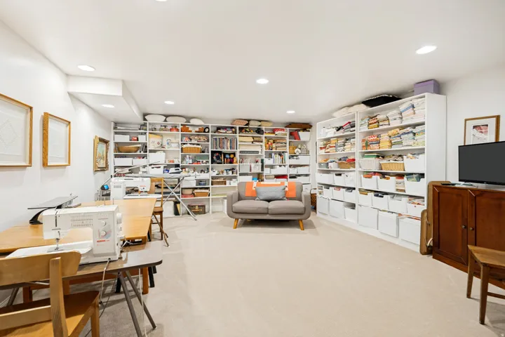 Spacious room featuring extensive built-in shelving, recessed lighting, and light-toned carpet flooring.