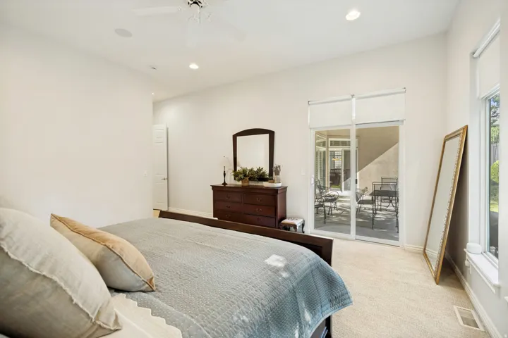 Primary bedroom featuring fresh painted walls, recessed lighting, a ceiling fan, and sliding door access to covered patio