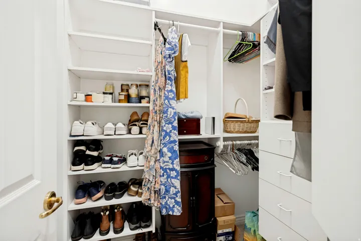 Custom closet system featuring multiple shelving units, hanging rods, and integrated drawers