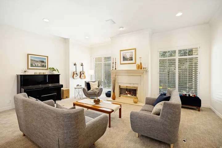 Living area featuring a classic fireplace with a substantial mantel, recessed lighting, and crown molding