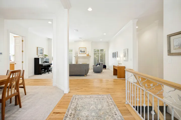 Hardwood flooring throughout the entry, crown molding, and recessed lighting