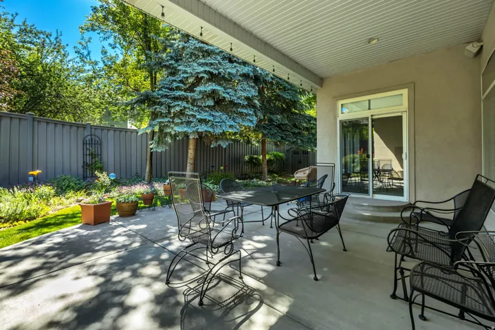 Expansive covered patio featuring a concrete surface, overhead lighting, and direct access to the interior via a sliding glass door