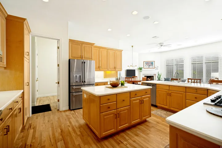 Expansive kitchen featuring oak hardwood flooring, custom maple cabinetry, and white countertops