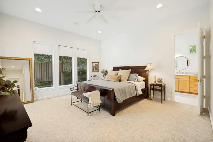 Carpeted primary bedroom with a vaulted ceiling, recessed lighting, and a ceiling fan