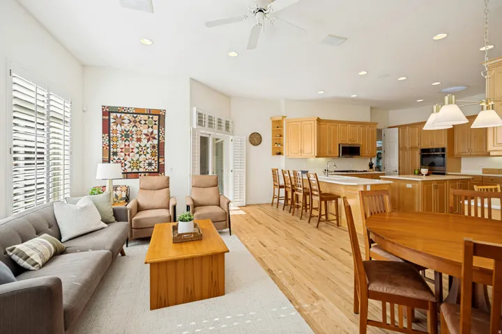 Open-concept family room featuring oak hardwood flooring, white plantation shutters, recessed lighting, and a ceiling fan