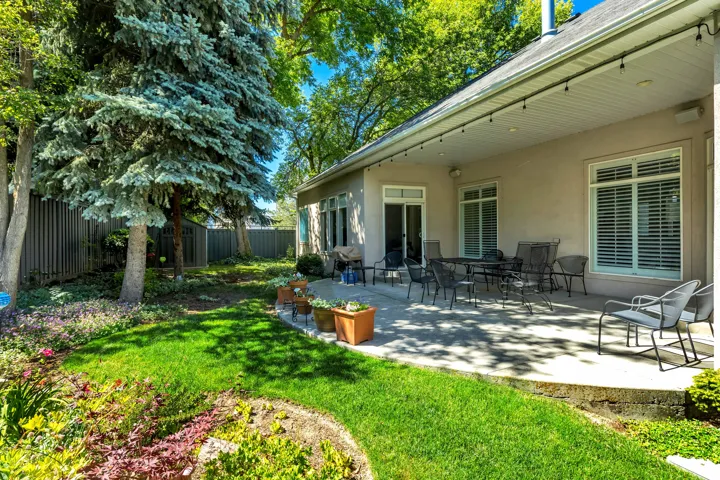 Exterior stucco siding with multiple windows featuring louvered shutters and a sliding glass door