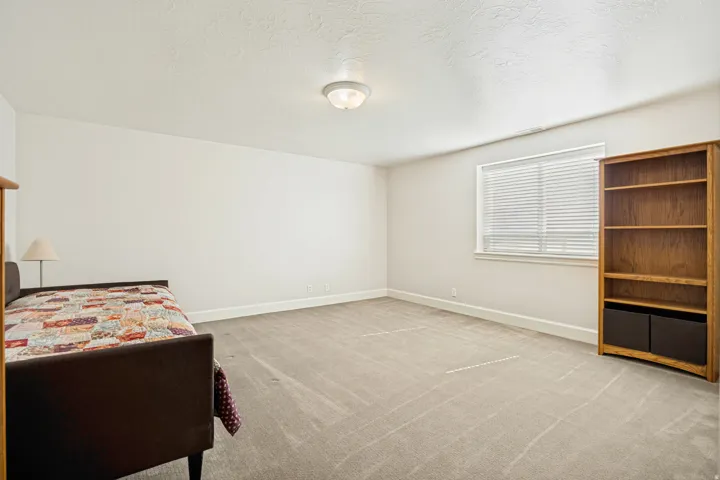Spacious bedroom with neutral-toned walls and carpeting