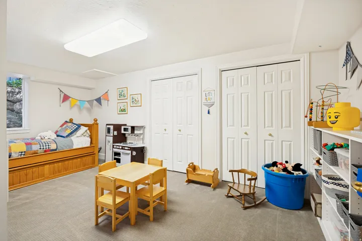 Spacious room featuring light-colored carpeting, two sets of bi-fold closet doors, and recessed lighting
