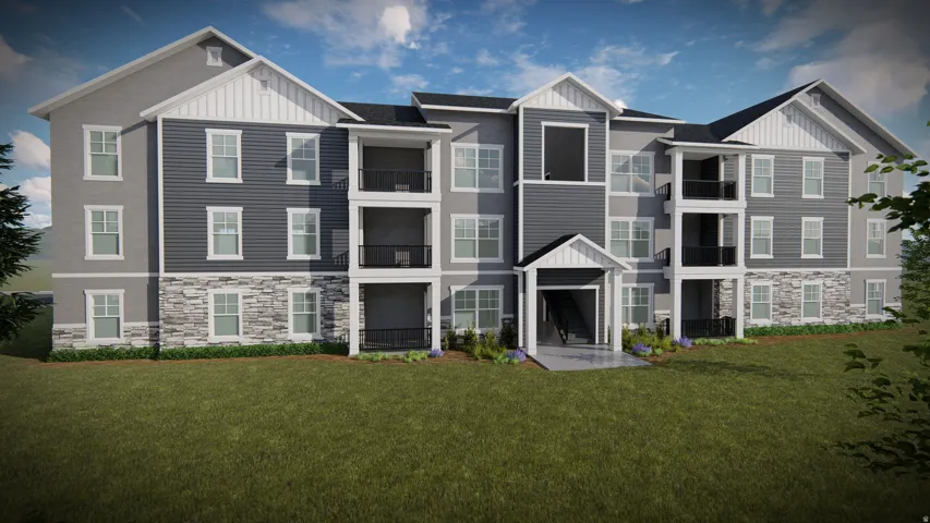 Multi-story building featuring gray siding, white trim, stone veneer accents, multiple balconies with black railings, and a prominent covered entryway