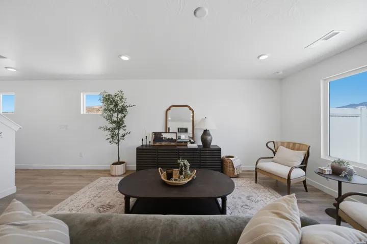 Bright living area featuring wood-finish flooring, recessed lighting, and large windows