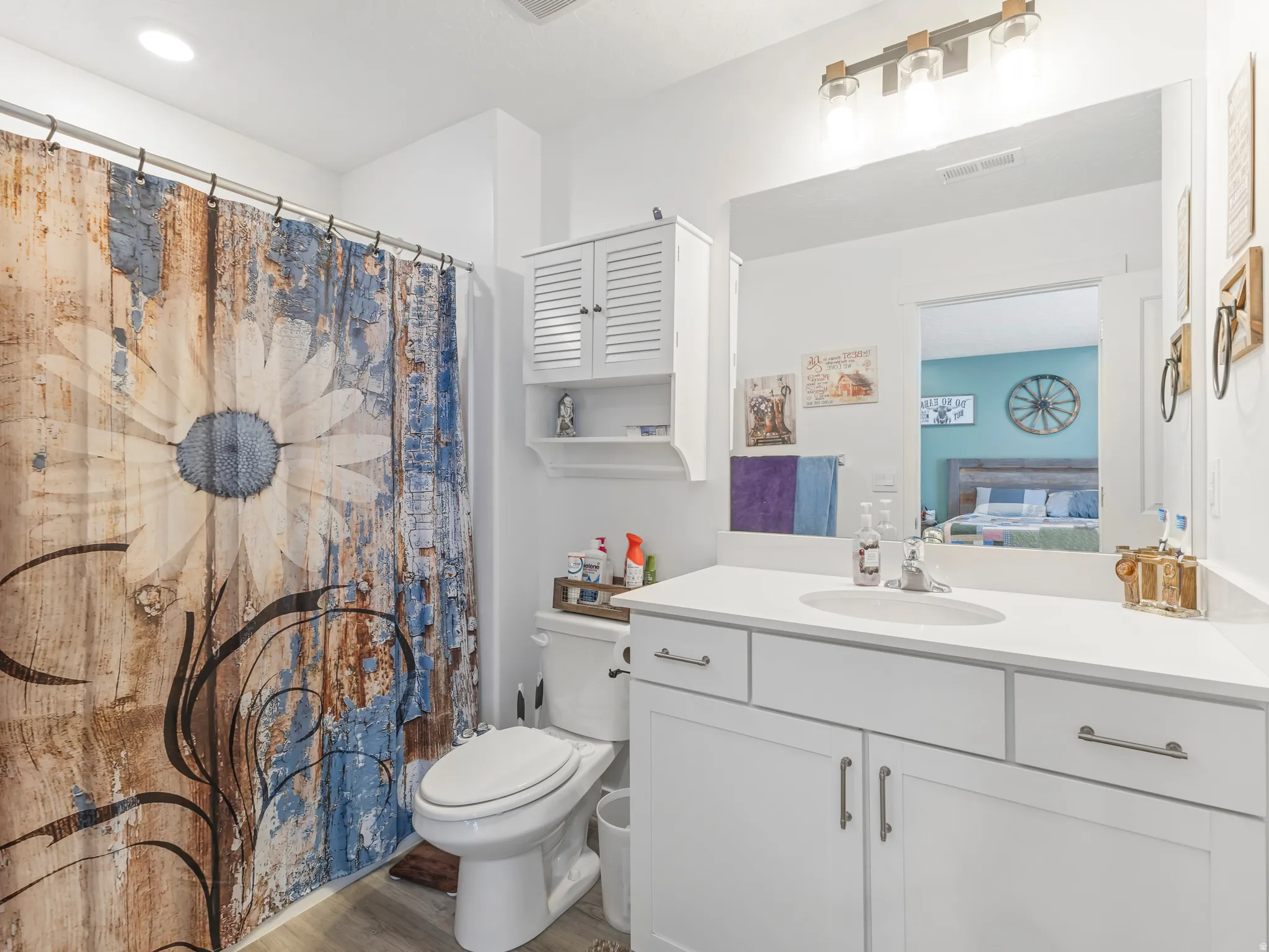 Bathroom featuring a single vanity with white cabinetry, a white countertop, and a built-in sink