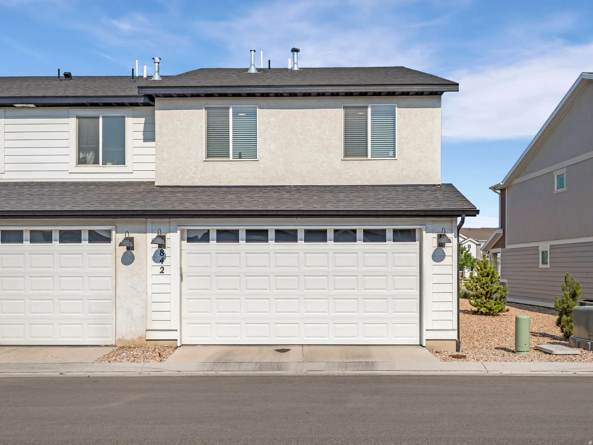 Two-story townhome exterior featuring stucco and siding finishes