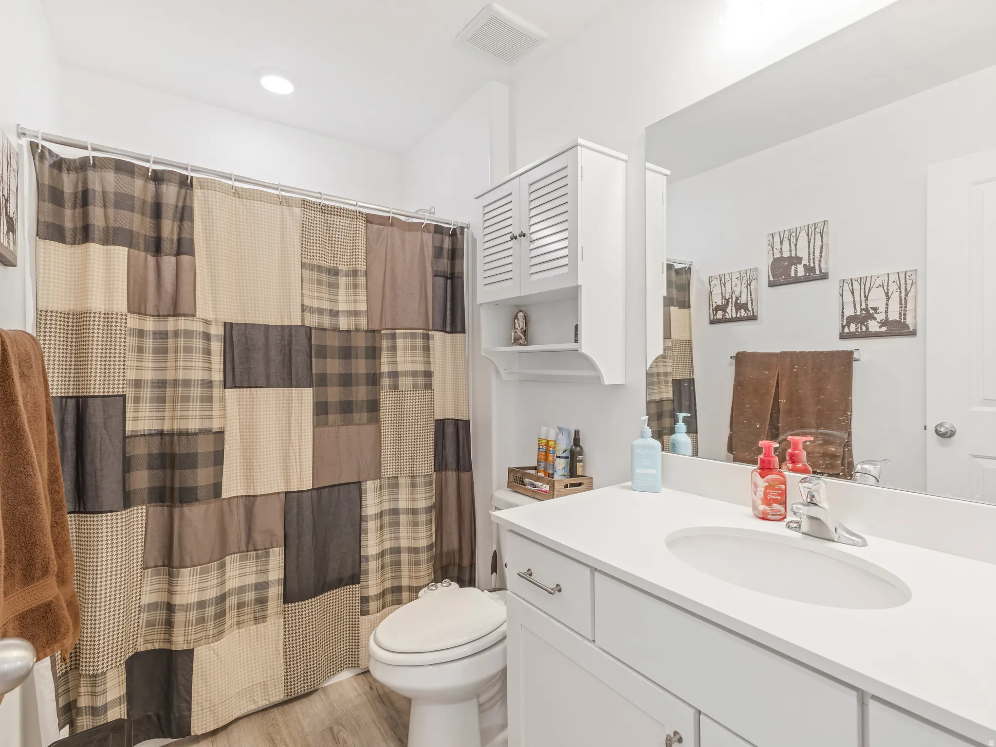 Bathroom featuring a white vanity with an integrated sink, polished chrome faucet, and white cabinetry