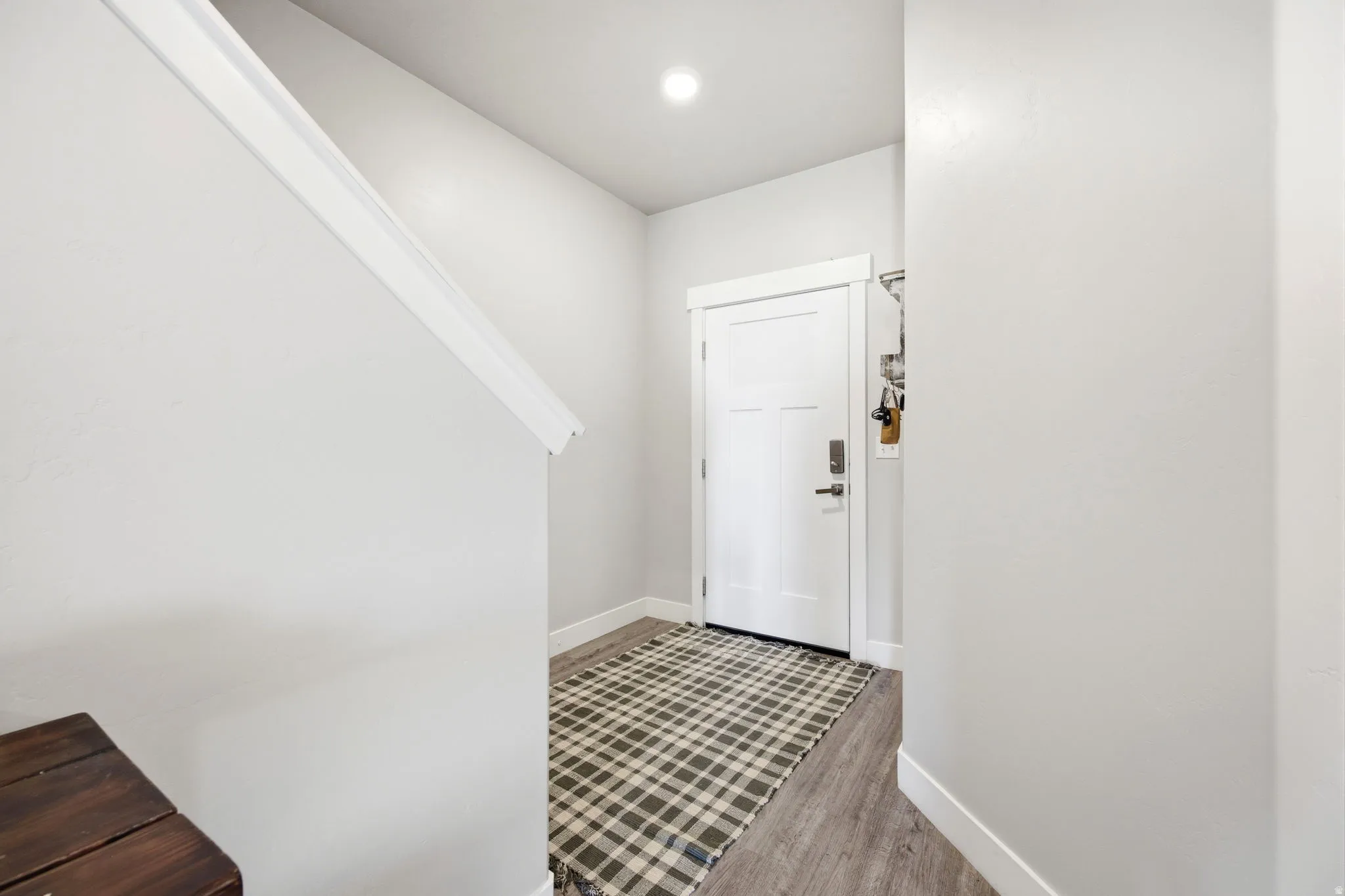 Welcoming entryway featuring a geometric patterned tile floor, white painted walls, recessed ceiling lighting, and a solid white entry door with satin nickel hardware