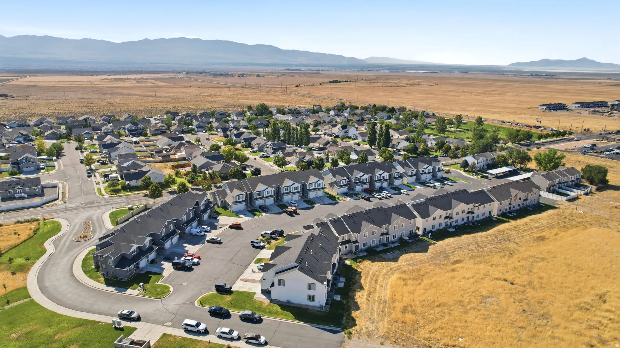 Aerial perspective showcasing a residential community with single-family homes and multi-unit townhomes