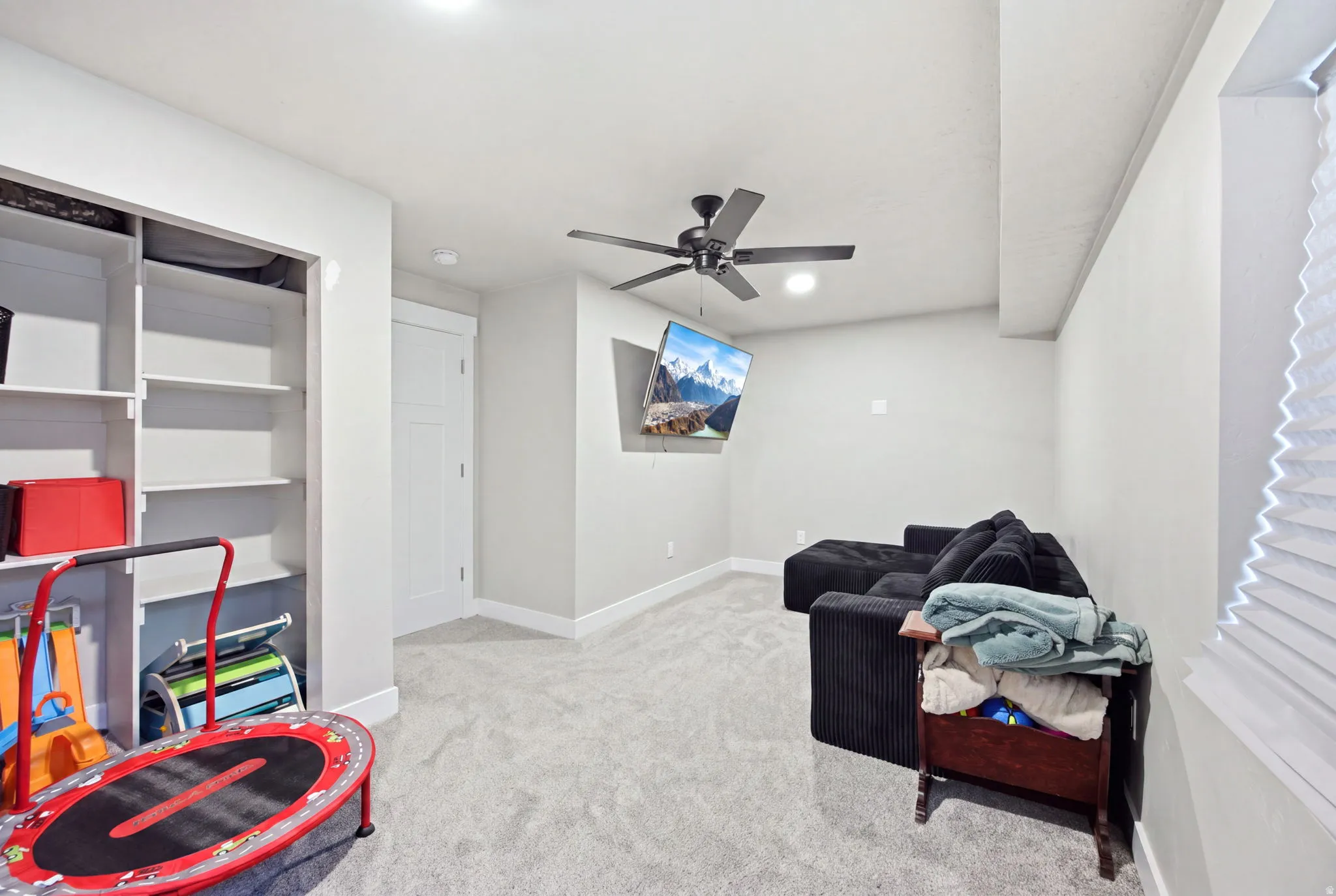 Carpeted room featuring recessed lighting, a ceiling fan, and a wall-mounted television