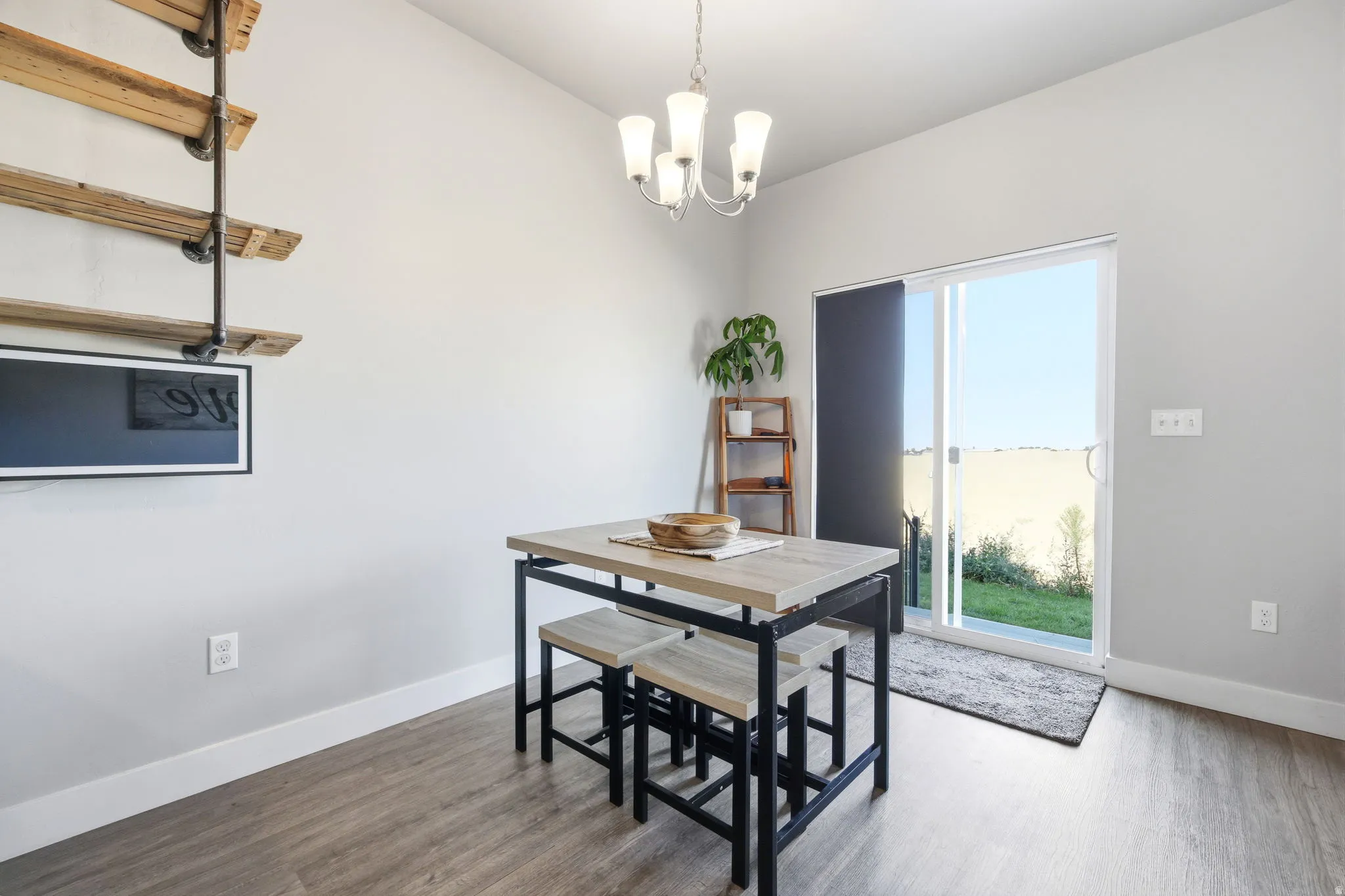 Modern dining space featuring a wood-finish island with integrated seating, pendant lighting fixture, and direct access to outdoor grounds through sliding glass doors
