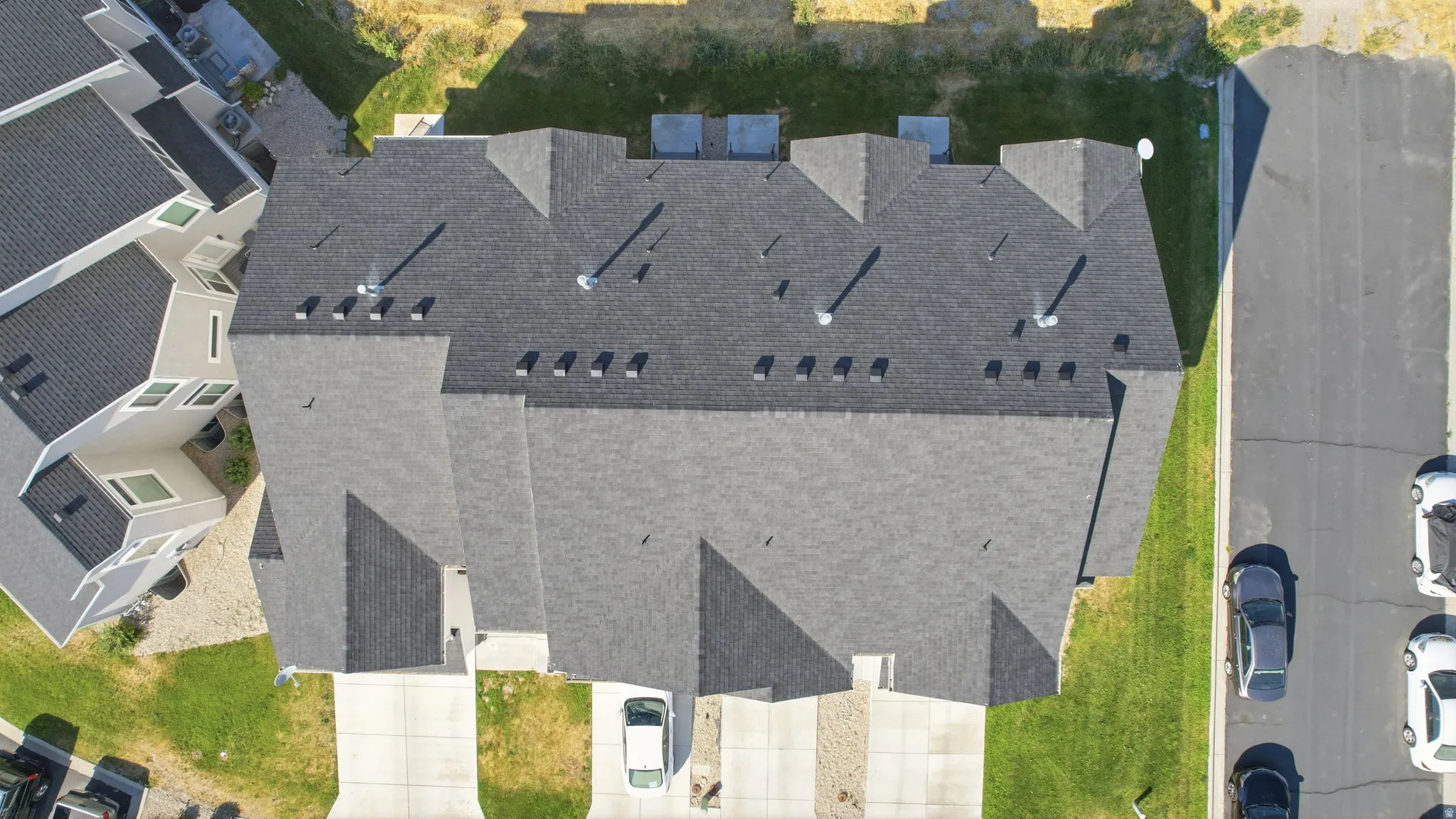 Townhome cluster featuring multiple pitched roofs with dark gray shingles