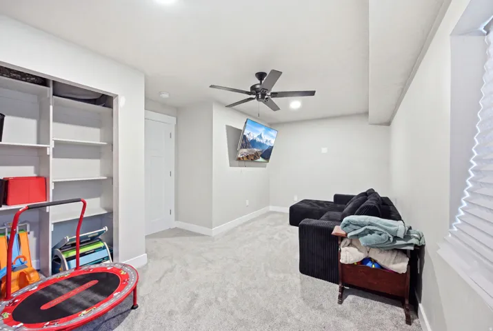 Carpeted room featuring recessed lighting, a ceiling fan, and a wall-mounted television