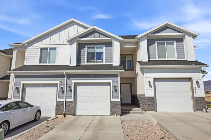 Modern two-story townhome featuring a clean, contemporary facade with mixed siding and stone accents