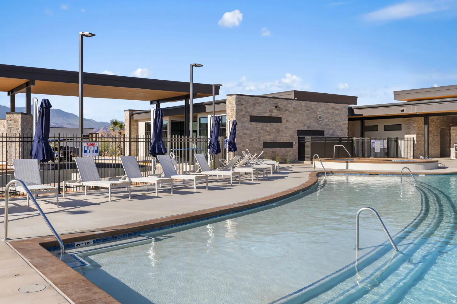 Curved swimming pool with integrated steps and metal handrails