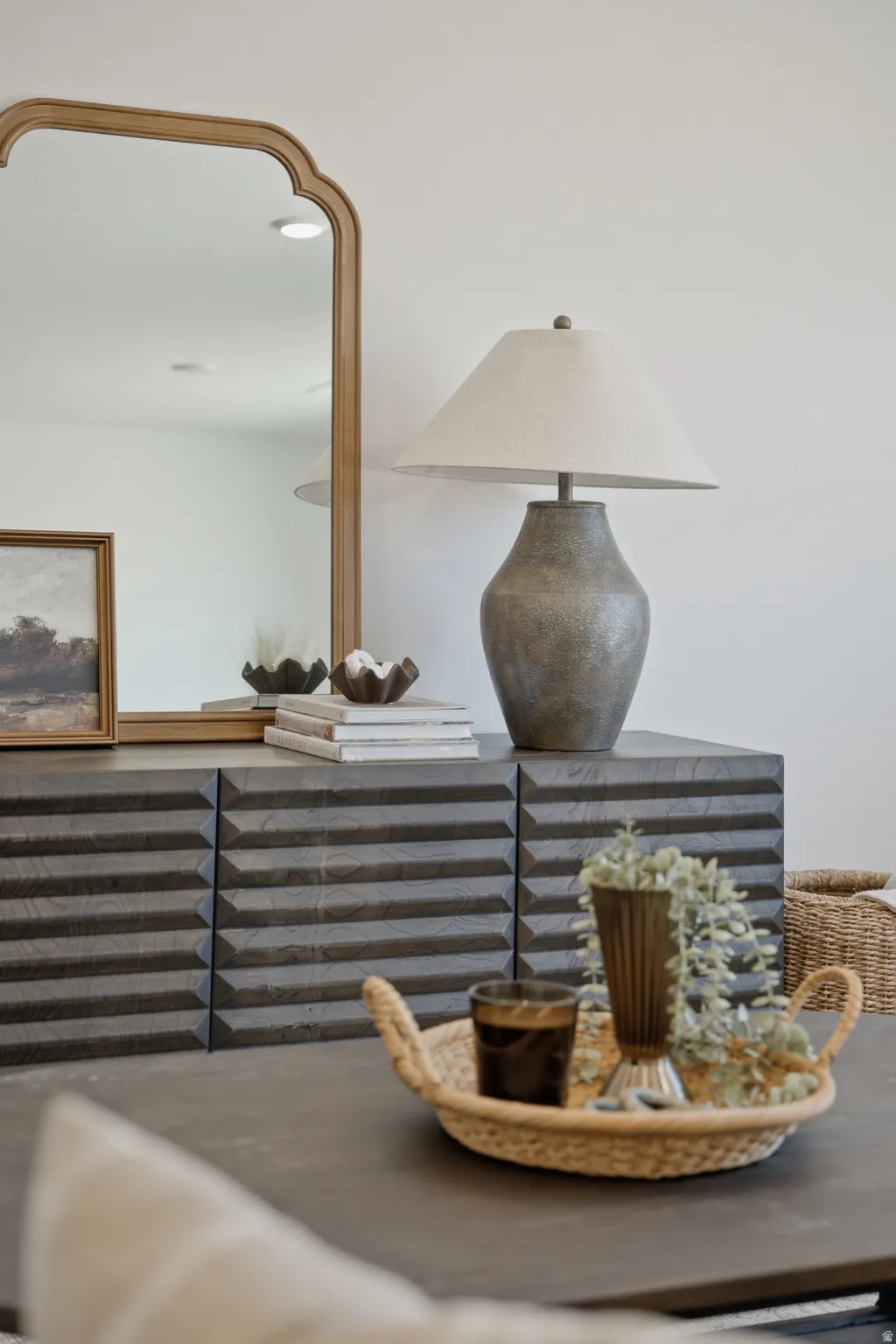Dark wood-finish credenza with a textured facade, featuring a light wood-framed mirror