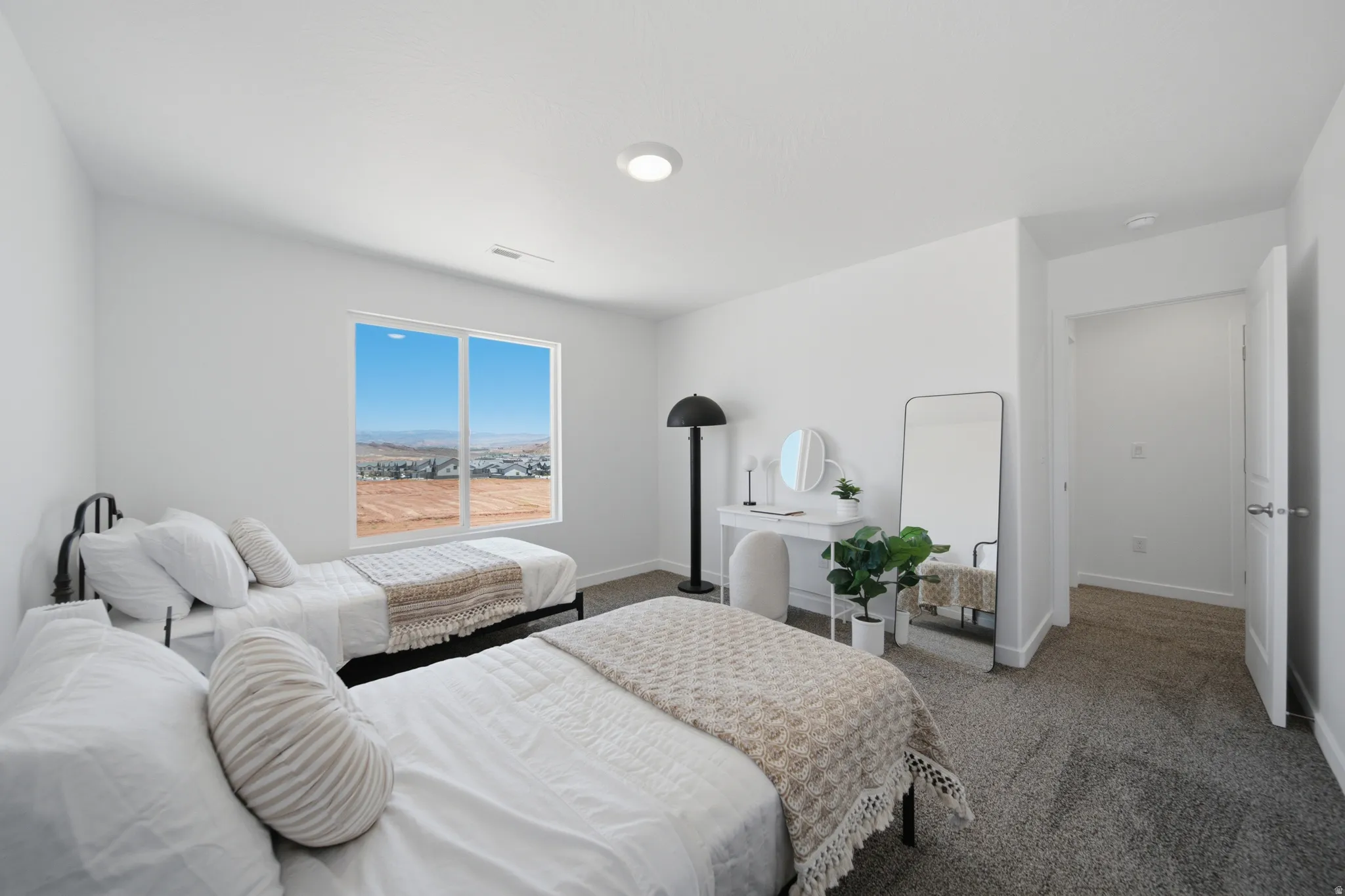 Bright room featuring a large window, plush carpet flooring, white walls, a recessed ceiling light, and a white interior door