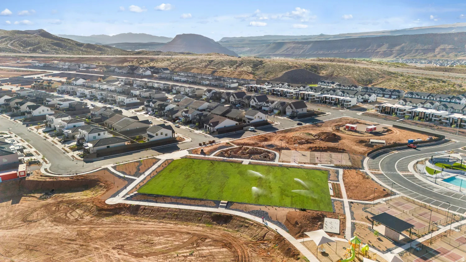 Newly constructed athletic field with professional-grade turf, bordered by modern curved hardscape edging and complementary landscaping
