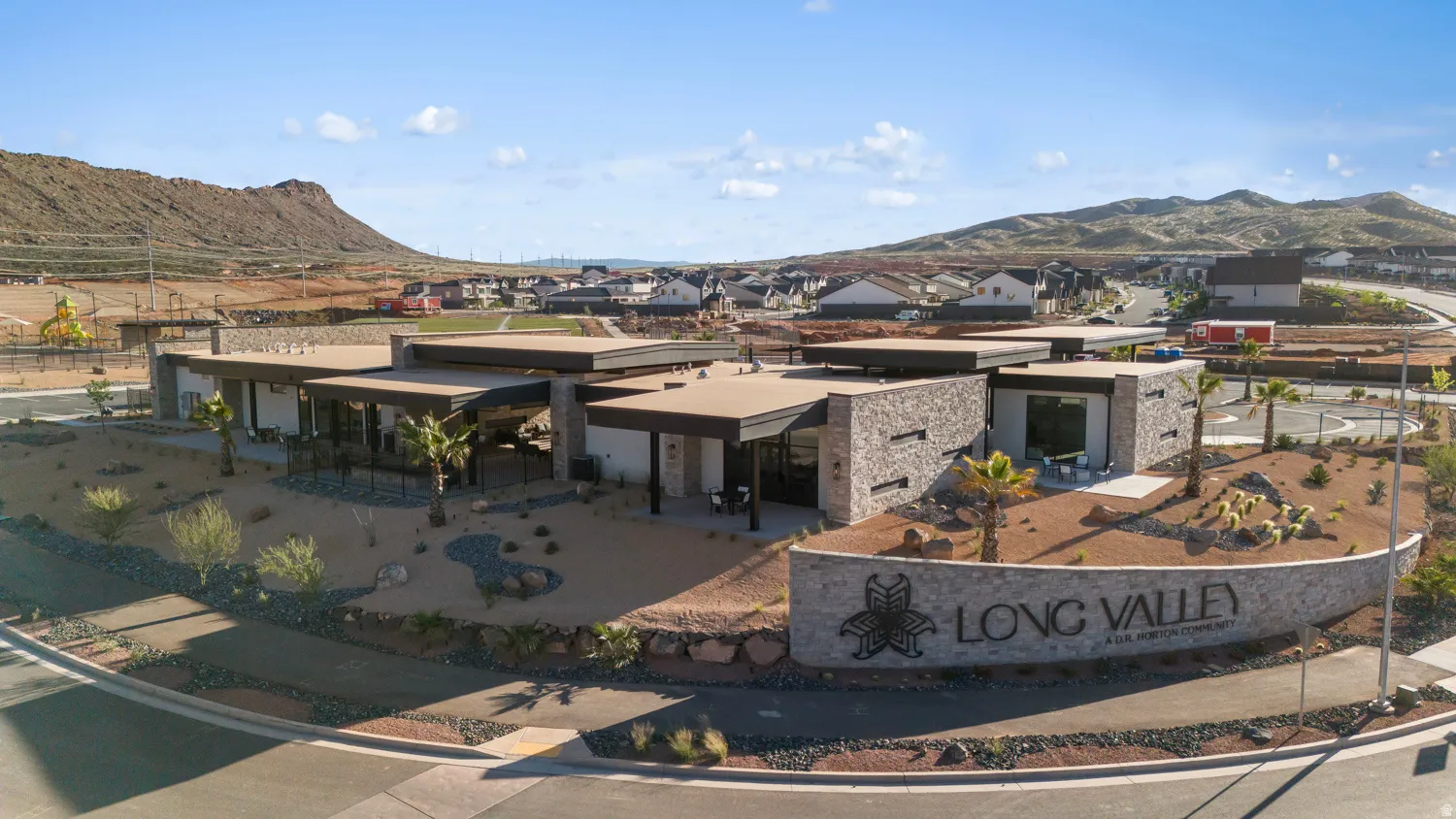 Modern community entrance featuring a stone-clad sign with "LONG VALLEY" lettering