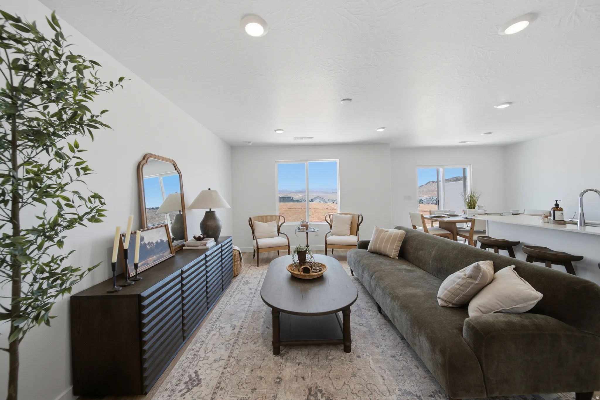 Open-concept living area featuring recessed lighting, large windows, and light-toned walls