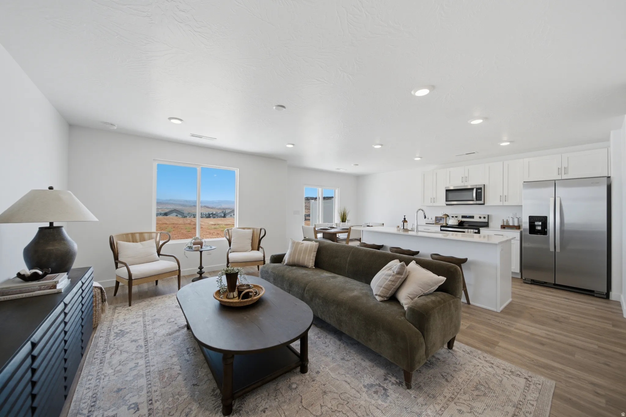 Open-concept living space featuring wood-finish flooring and recessed lighting