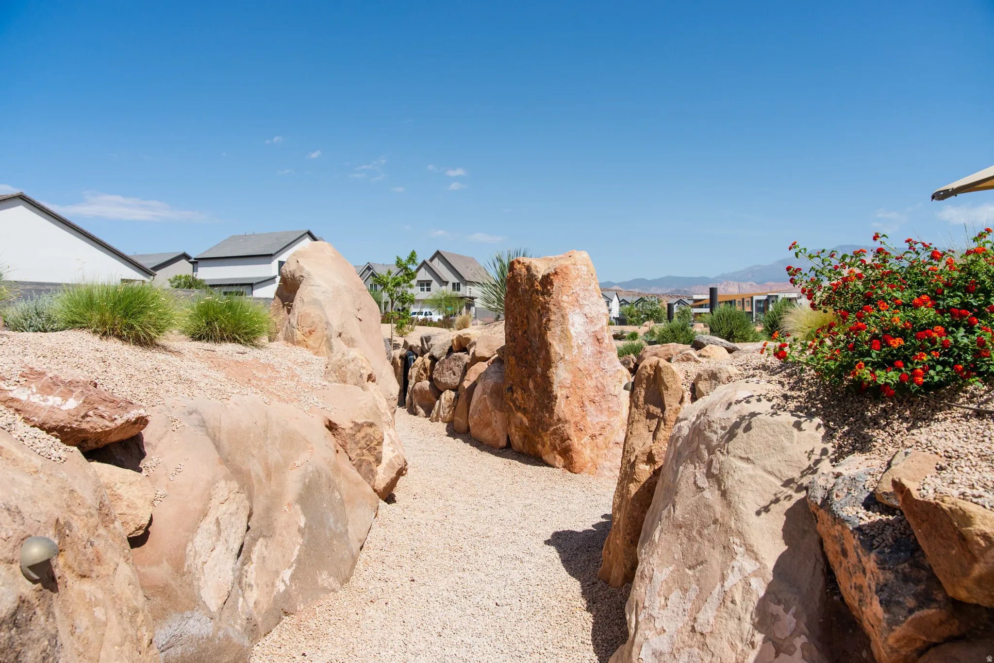 Desert-inspired landscaping featuring a gravel pathway framed by natural rock formations