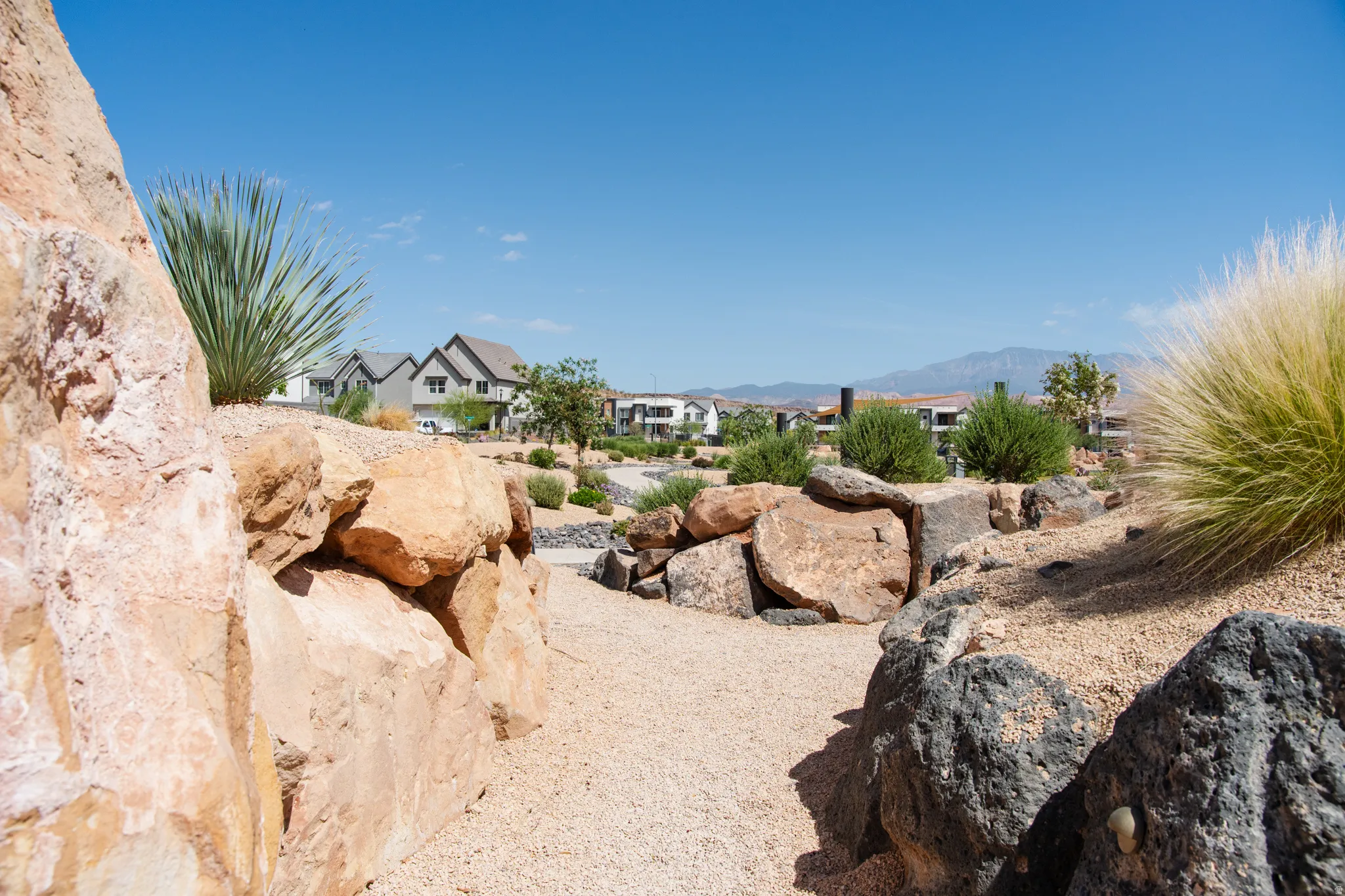 Desert-inspired landscaping featuring a gravel path and natural rock formations