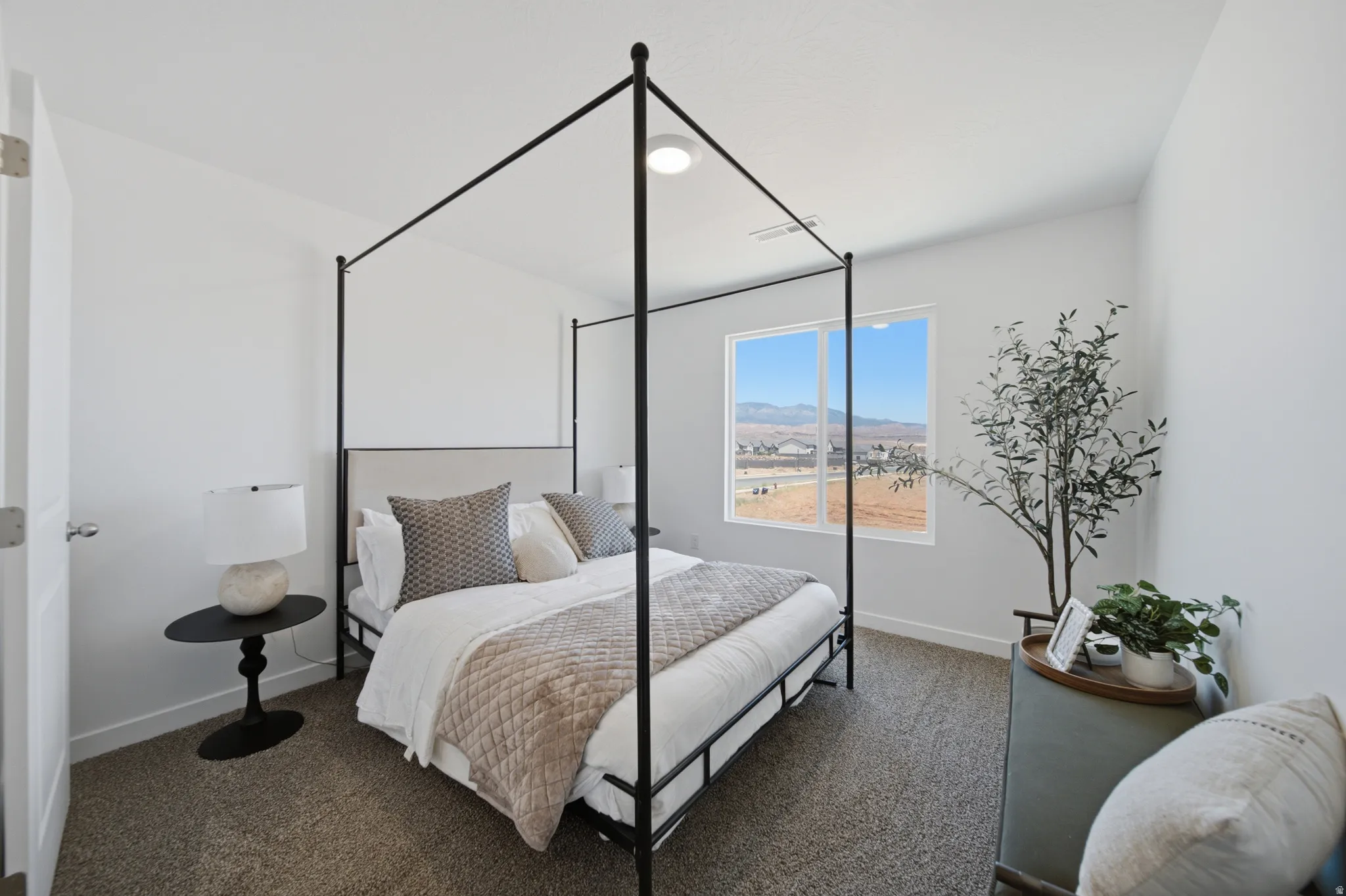 Spacious interior room featuring a large window, neutral wall paint, and textured carpeting