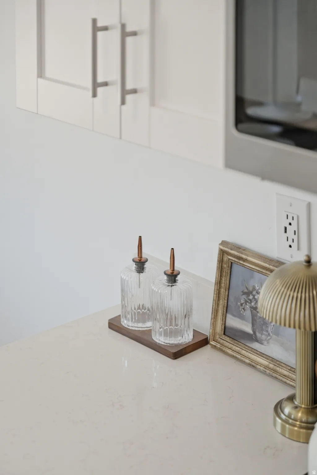 Light-toned countertop with subtle veining, paired with white shaker-style cabinetry featuring brushed nickel hardware