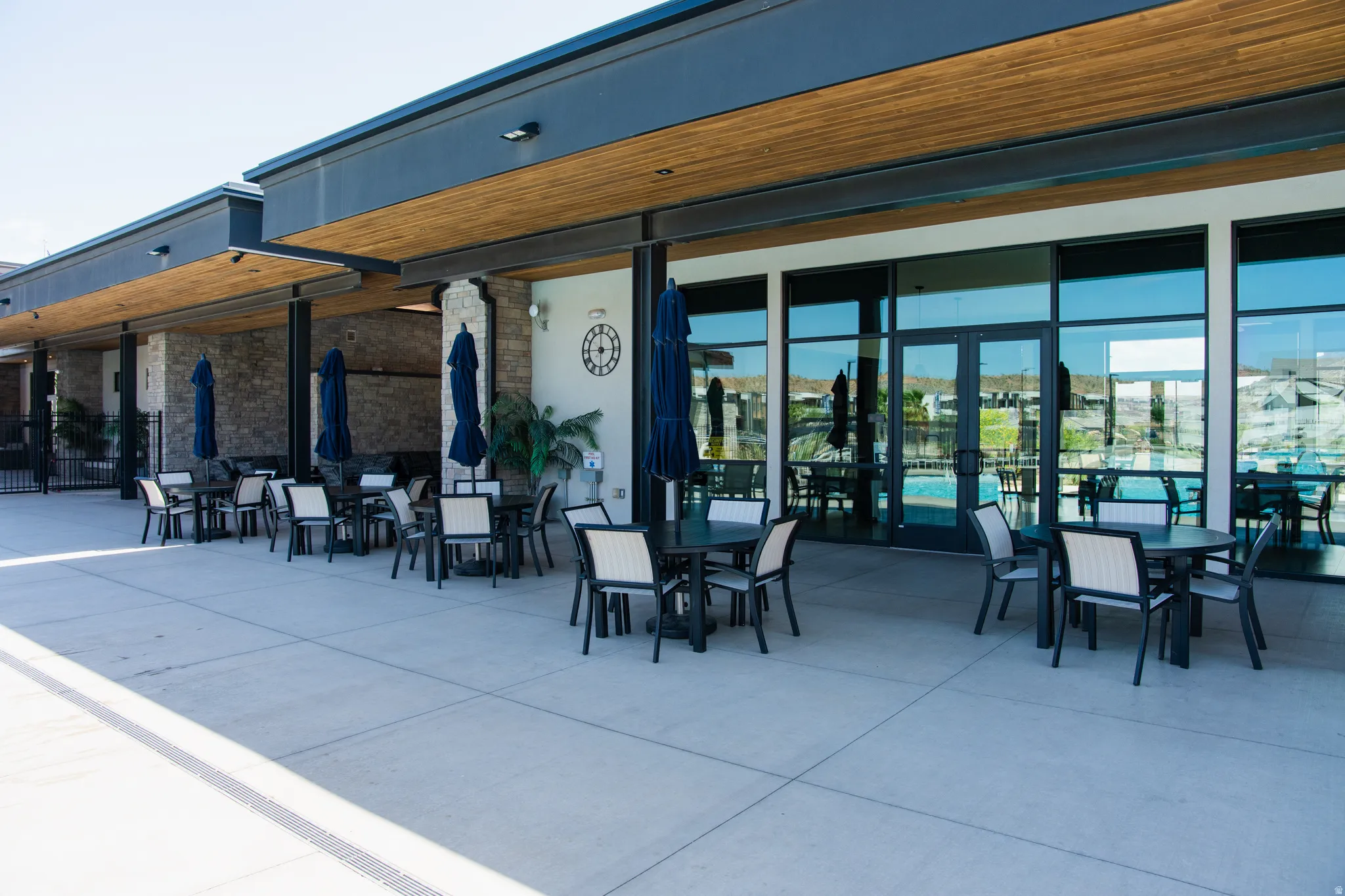 Expansive outdoor patio with concrete flooring and multiple seating areas