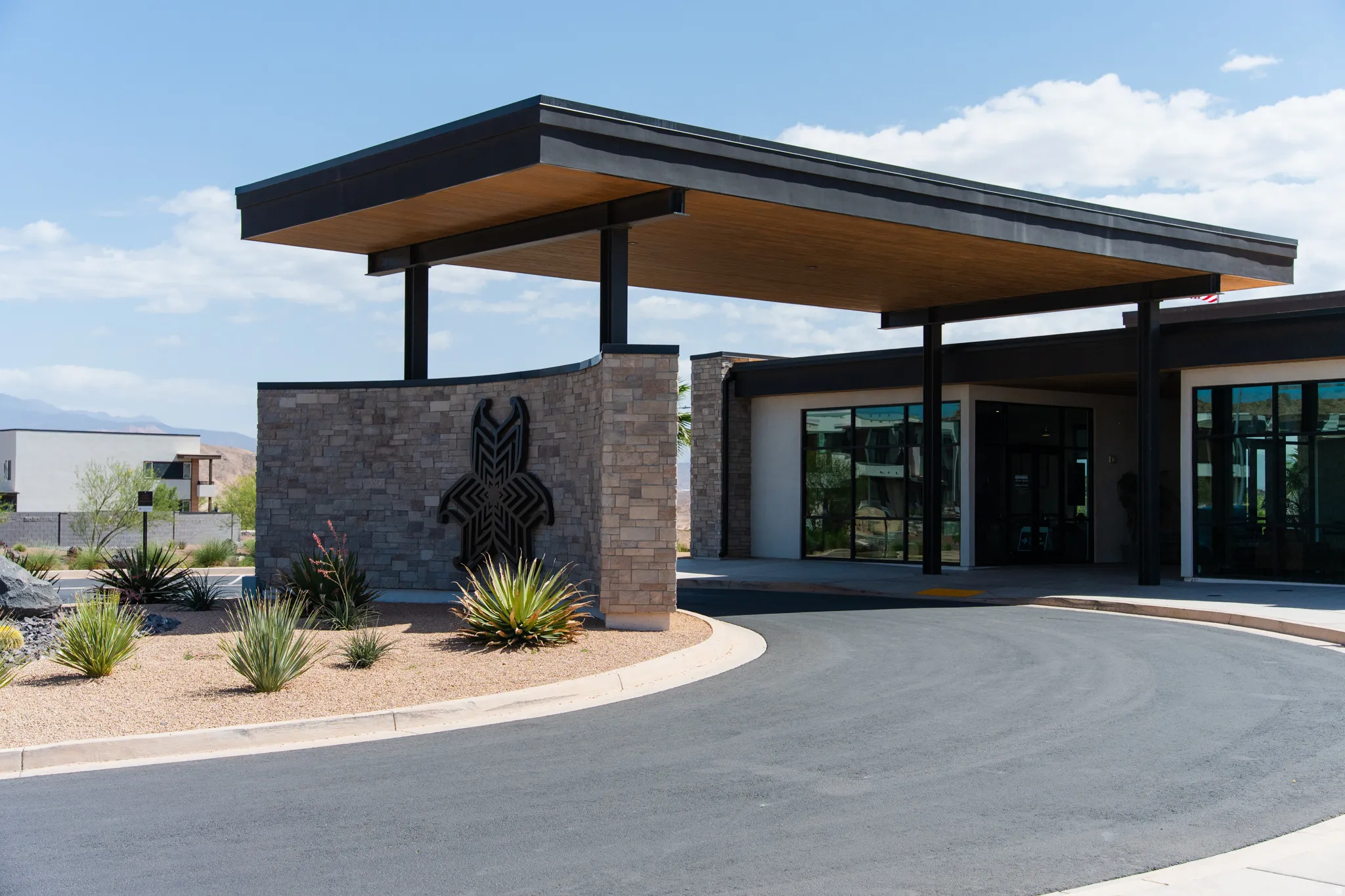 Modern porte-cochere entry with a wood-finish ceiling and dark structural beams