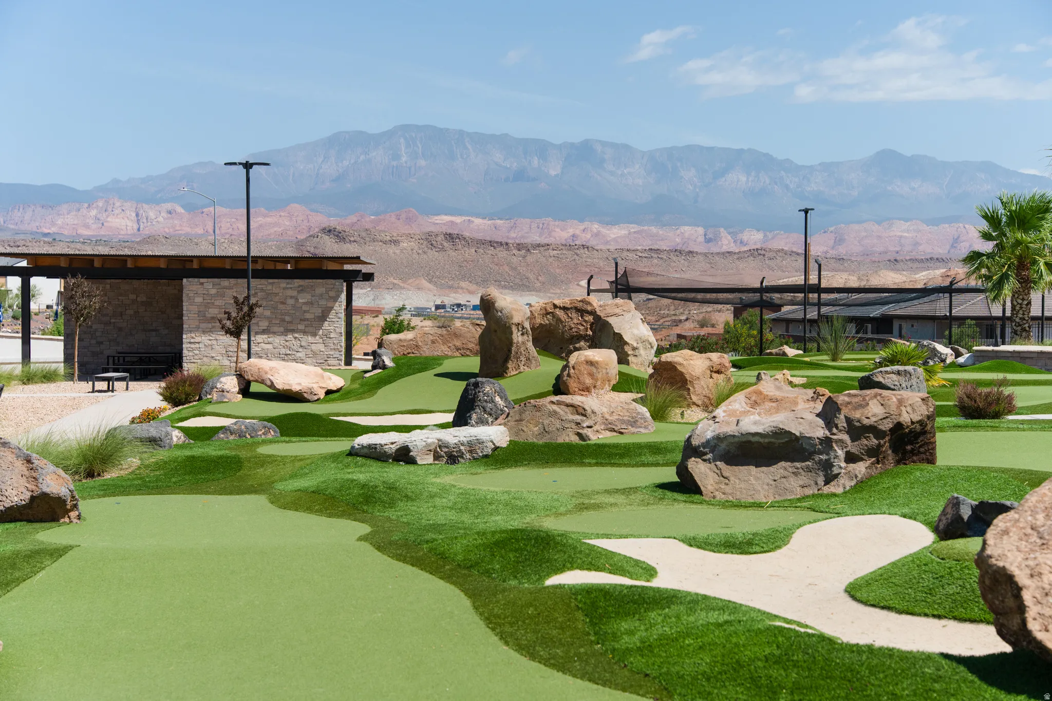 Expansive putting green featuring sand traps and substantial rock landscaping