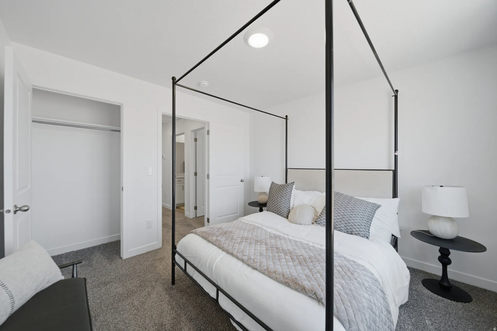 Carpeted bedroom featuring a built-in closet, flush-mount lighting, and white trim