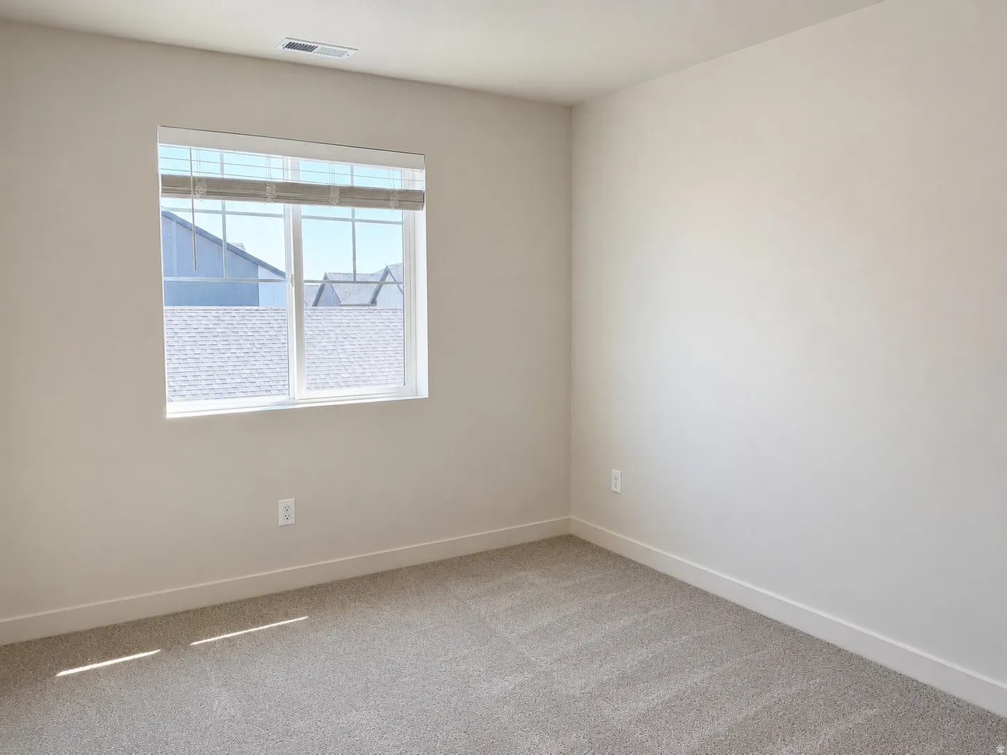 Neutral-toned walls complement the gray carpeting