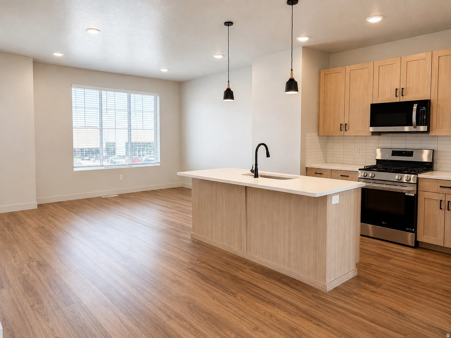 Open-concept living space featuring wood-finish flooring and recessed lighting