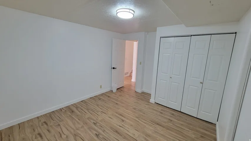 Wood-finish flooring, white walls, and a bi-fold closet
