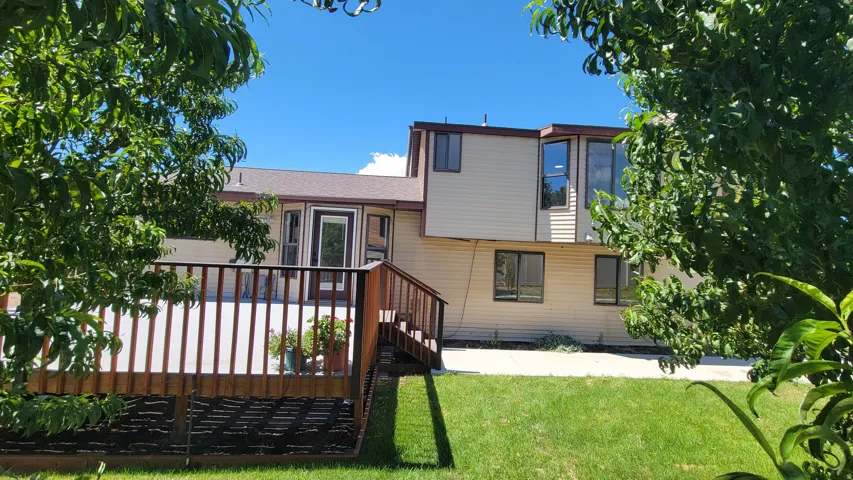 Expansive rear deck with wooden railings, providing a spacious outdoor living area