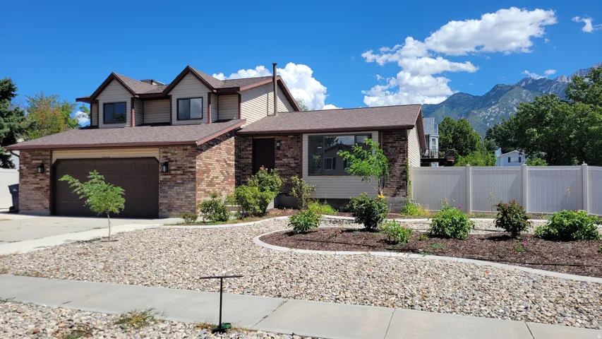 Two-story residence featuring brick and siding exterior, an attached two-car garage, and a brown shingle roof