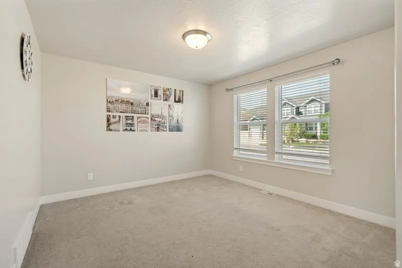 Neutral wall tones complement plush carpeting throughout this bright room
